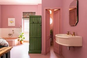 baño con armario verde junto a un lavabo en Hotel Lola, en Ciudad del Cabo