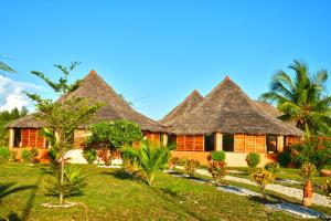 un complejo con techos de paja y palmeras en Nosy Saba Private Island & Spa, en Nosy Saba