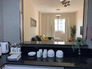 une cuisine avec un comptoir et un salon dans l'établissement A Calm&Cozy 1BR-20 MIN-DXB AIRPT, à Dubaï