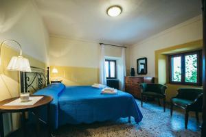 a bedroom with a blue bed and a table and chairs at Casa Vacanza La Pozza in Molazzana