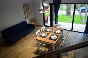 a living room with a table and chairs and a blue couch at Тузлата пентхаус / Tuzlata penthouse in Balchik
