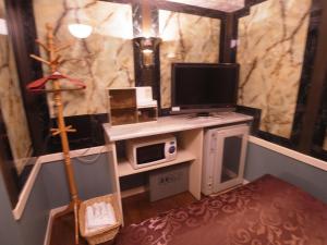 a room with a desk with a computer and a tv at SKYROAD Adult Only in Tokyo