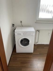 a washing machine in a small room with a window at Ferien & Monteurwohnung in Bohmte-Hunteburg in Bohmte