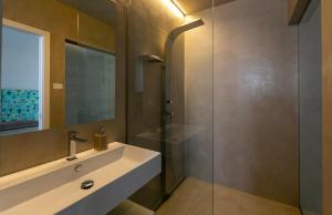 a bathroom with a sink and a glass shower at Attico Terrammare in Trapani +29 photos