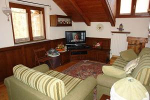 a living room with two couches and a flat screen tv at Bonne Ville in Cesana Torinese