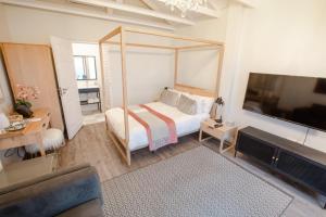 a bedroom with a bed and a flat screen tv at Essenwood House in Durban