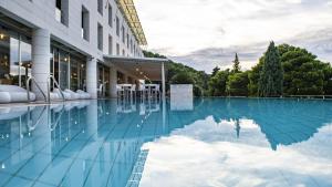 a swimming pool in front of a building at Hotel Uvala in Dubrovnik