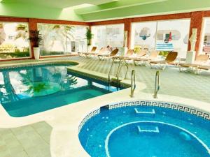 a pool in a hotel with chairs and a swimming pool at Casa Hibiscus Marbella in Marbella