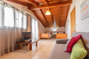 a living room with a couch and a tv at Eleni Luxury Villa in Almiros Beach