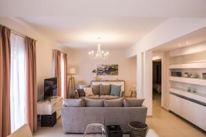 a living room with a couch and a tv at Eleni Luxury Villa in Almiros Beach
