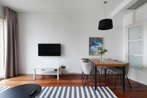 sala de estar con mesa y TV en numa l Lumino Apartments, en Barcelona