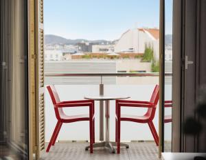 バルセロナにあるnuma l Lumino Apartmentsのバルコニー(テーブル、椅子2脚付)