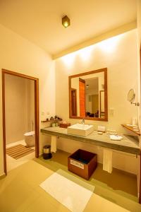 uma casa de banho com um lavatório, um WC e um espelho. em The Residence Hikkaduwa em Hikkaduwa