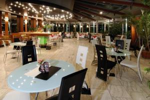 a restaurant with white tables and chairs and lights at Hotel Dukla in Prešov