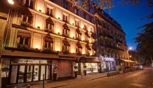 a building on the side of a street at night at Hôtel Du Midi Paris Montparnasse in Paris