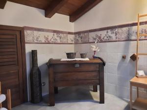 a bathroom with a wooden table in a room at Amaranto99 in LʼAquila