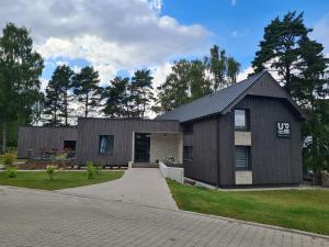 a house with a black roof at Viesu nams UPE in Roja