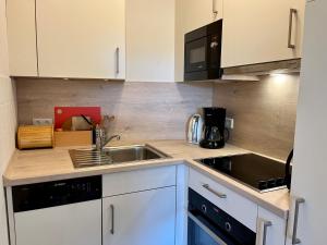 a kitchen with a sink and a microwave at Ferienappartement Peters in Glücksburg