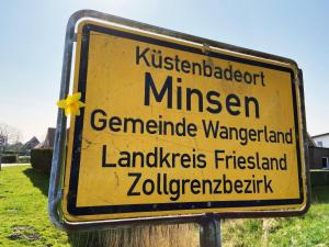 a yellow sign that is on a pole at Ferien im Wangerland Ferienwohnung INSEL Minsen Schillig Hund Pool Sauna in Wangerland