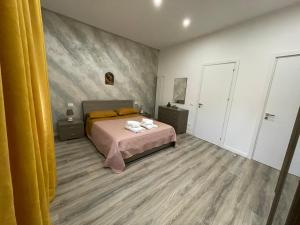 um quarto com uma cama e uma cortina amarela em Dimora del Buongustaio em Palermo