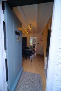 un corridoio che conduce a una sala da pranzo con tavolo di 4 Danes Cottages - perfect location a Lincoln