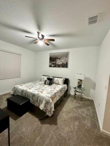 a bedroom with a bed and a ceiling fan at Grand Family Deluxe 4BR House near Disney Parks in Davenport