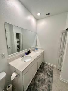 uma casa de banho com 2 lavatórios e um espelho grande em Grand Family Deluxe 4BR House near Disney Parks em Davenport