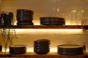 a shelf with plates and bowls on it at 4 Danes Cottages - perfect location in Lincoln