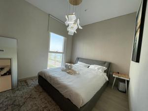 un osito de peluche sentado en una cama en un dormitorio en Smart Living Apartment en Abu Dabi