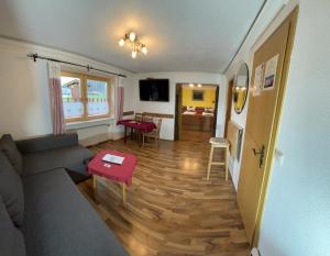 a living room with a couch and a table at Hotel - Pension Alpenstern in Schönau am Königssee