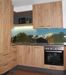 uma cozinha com armários de madeira e um forno com placa de fogão em Gasthof Bergblick em Berwang
