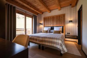 a bedroom with a bed and a table and a window at CHALET LA MANIGODINE Piscine 18-24 pers in Manigod