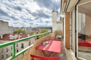 a red table on a balcony with a view of a city at New ! Cosy Apt, ideal couple centre de Boulogne in Boulogne-Billancourt