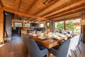 a dining room with a long wooden table and chairs at CHALET LA MANIGODINE Piscine 18-24 pers in Manigod