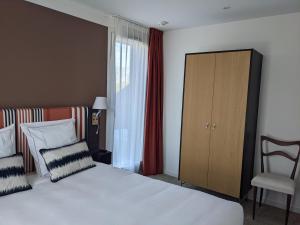 een hotelkamer met een bed en een stoel bij HOTEL LE 25 in Andernos-les-Bains