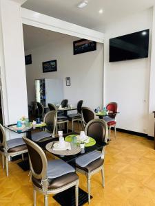 une salle avec des tables, des chaises et un écran de projection dans l'établissement Enzo Hotels Limoges Centre Jourdan by Kyriad Direct, à Limoges