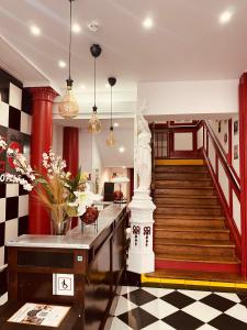 un hall avec un escalier et une statue au milieu dans l'établissement Enzo Hotels Limoges Centre Jourdan by Kyriad Direct, à Limoges