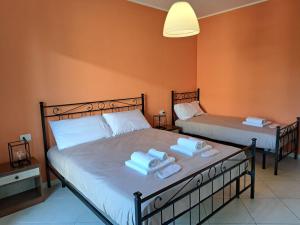 two beds in a room with towels on them at Navili Grand Apartment in Trezzano sul Naviglio