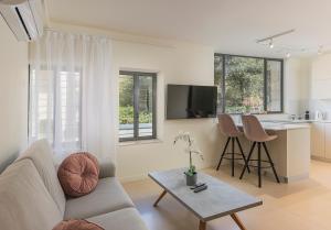 a living room with a couch and a table at The Pearl of Nachlaot Apartments in Jerusalem