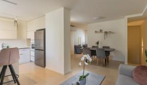 a kitchen and living room with a table and chairs at The Pearl of Nachlaot Apartments in Jerusalem