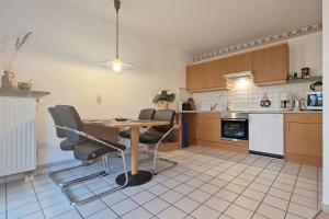 een keuken met een tafel en stoelen in een kamer bij Waldschlösschen in Ostseebad Sellin