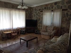 sala de estar con sofá y TV en Rincón de la selva en La Calera