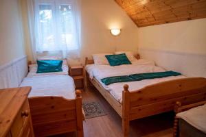 バラトンフェニヴェシュにあるApartment Balatonfenyves/Balaton 18401のベッドルーム1室(ベッド2台、木製テーブル付)
