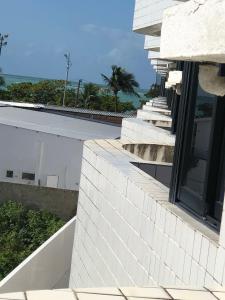 - un bâtiment blanc avec vue sur l'océan dans l'établissement Mar e Sol da Pajuçara, à Maceió