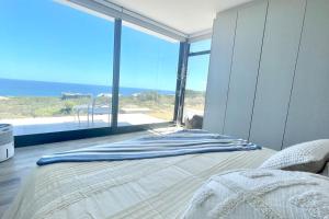 a bedroom with a bed with a view of the ocean at Exclusive luxury & lifestyle suite in Mossel Bay