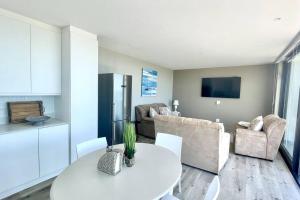 a kitchen and living room with a white table and chairs at Exclusive luxury & lifestyle suite in Mossel Bay