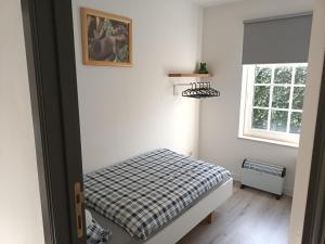 a small bedroom with a bed and a window at Kanaalzicht21 in Hasselt