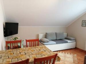 uma sala de estar com um sofá e uma mesa com cadeiras em Laci Apartman em Zalakaros