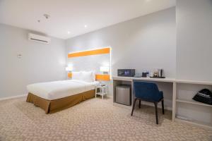 a bedroom with a bed and a desk and a chair at Holiday Inn Express & Suites Johor Bahru, an IHG Hotel in Johor Bahru