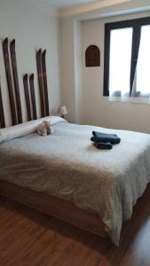 Un dormitorio con una cama con un osito de peluche. en Apartamento Riglos Candanchu, en Candanchú